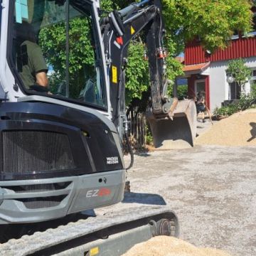 Der Bagger verteilt den Jurakalk auf dem Schulhof