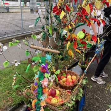 Ein Bollerwagen mit Baum und Äpfeln.